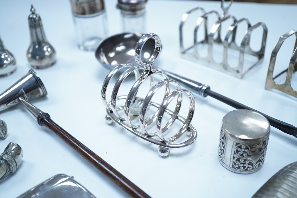 A group of assorted silver, to include a pair of modern five bar toast racks, a George V card case, a sterling vesta case, four assorted condiments, two mounted toilet bottles, mounted timepiece, a modern wooden handled